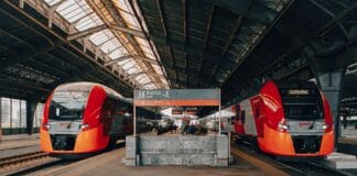 Czy kolej to przyszłość transportu w Polsce głosy czytelników i prognozy Czerwono‑czarne pociągi na ruchliwym dworcu kolejowym z pasażerami