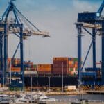 Port przemysłowy z dźwigami przeładunkowymi i kolorowymi kontenerami