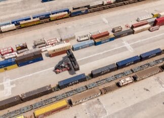 Jak powstaje węzeł multimodalny: kolej, autobusy, rowery i piesi w jednym miejscu Widok z drona na centrum logistyczne z kontenerami i wózkiem widłowym
