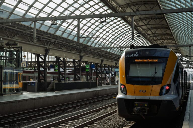 Nowoczesny pociąg na stacji Amsterdam Centraal pod szklanym dachem